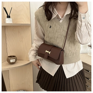 Brown leather crossbody bag with golden H-buckle styled with autumn knitwear outfit