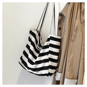 Close-up of black and white striped canvas tote bag texture with long shoulder straps