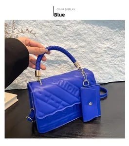 Close-up of blue quilted leather bag with FASHION logo and woven handle detail