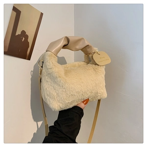 Detailed shot of beige plush handbag featuring knotted leather handle and fuzzy texture