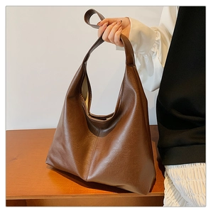 Detail of vintage brown leather tote bag with soft texture and refined side stitching