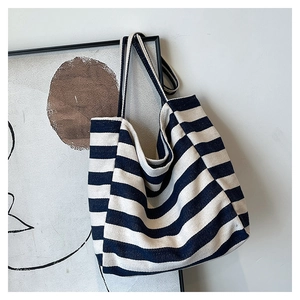Detail of navy stripe canvas tote bag with thick shoulder straps hanging on a wall frame