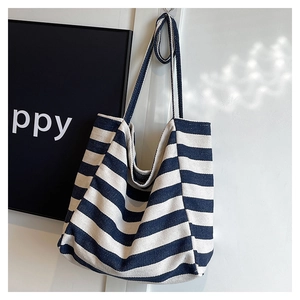 Detailed view of the thick canvas texture and blue horizontal stripes on the tote bag