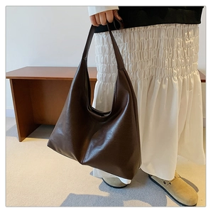 Close-up of a large dark brown Hobo bag with visible leather texture and center stitching