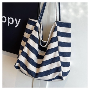 Detailed close-up of blue and white striped canvas tote bag fabric texture and shoulder straps