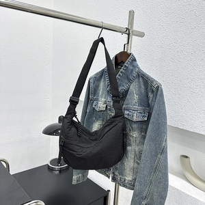 Minimalist black crescent crossbody bag with adjustable wide strap and nylon texture