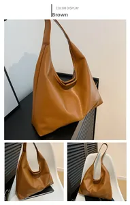 Detail of a brown large capacity tote bag featuring a textured pleated soft PU leather surface