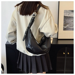 Detail of black crescent moon bag with adjustable strap and silver metal buckle
