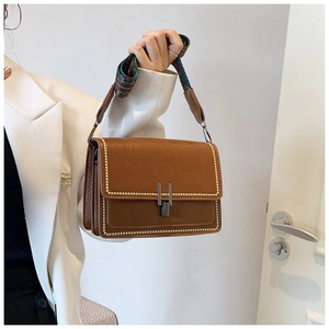 Brown vintage leather crossbody bag with ethnic patterned strap and metal buckle detail