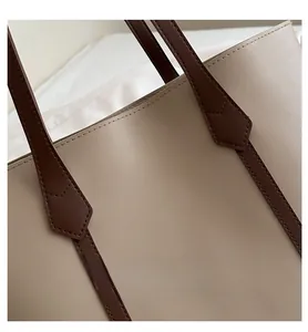 Detail der Litschi-Textur aus Kunstleder und verstärkten Kontrastnähten an der Shopper-Tasche
