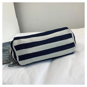 Macro shot of striped canvas cylinder tote showing blue and white fabric texture