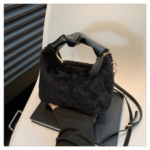 Detail of black plush handbag with faux fur texture and knotted leather metal chain handle