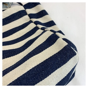 Detailed close-up of blue and white striped canvas tote with reinforced bottom stitching