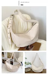 Detail of off-white hobo bag showing adjustable wide strap and smooth synthetic leather