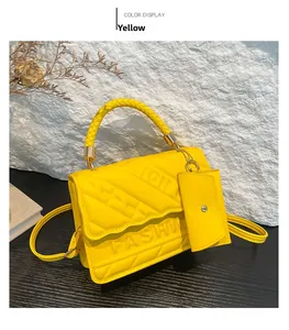 Detail of yellow quilted PU leather crossbody bag with FASHION embossing and mini pouch