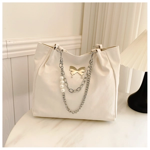Detail of cream white tote bag with silver butterfly charm and decorative large pearls