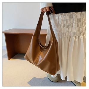 Side view of large brown PU leather hobo bag with wide shoulder strap and natural texture