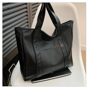 Close-up of black PU leather tote bag with vintage wrinkled texture and wide straps