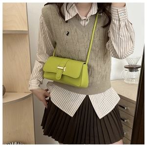 Chic green leather baguette crossbody bag with flap cover and golden metal buckle