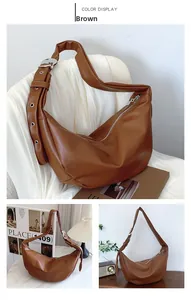 Detail of a brown PU leather crescent hobo bag with adjustable eyelet shoulder strap