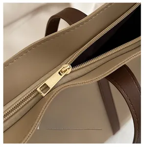 Detaillierte Makroansicht des glatten goldenen Reißverschlusses und der Naht der Handtasche