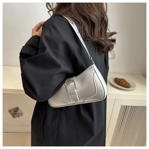 Foto lifestyle di una borsa sottobraccio argento con fibbia indossata da modella