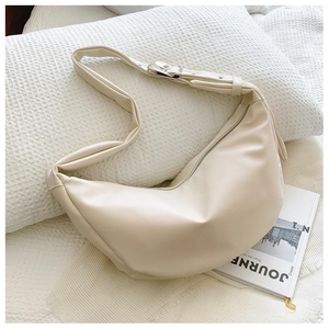 Detail of cream hobo bag with pebble leather texture and adjustable silver buckle strap