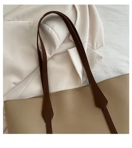 Nahaufnahme des bequemen Griffs und der oberen Öffnung einer beigen Leder-Tote-Bag