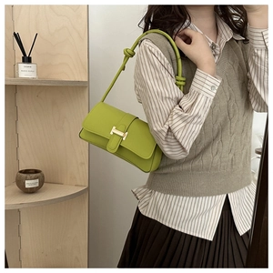 Green leather crossbody bag with gold H-buckle shown on a model in a mirror selfie