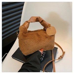 Detail of caramel plush tote with wrinkled leather handle and decorative tag