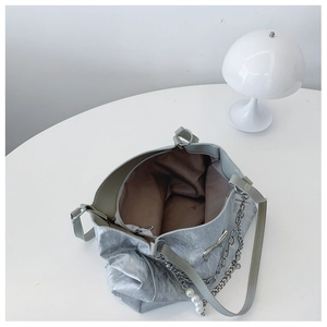 Detail of silver tote bag interior with zipper pocket and metal bow hardware