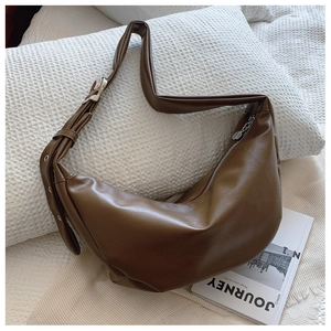Macro detail of dark brown leather hobo bag with adjustable silver buckle strap