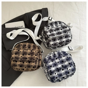 Detailed view of mini checked crossbody bags with heart patterns and wide canvas straps
