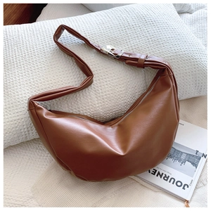 Detail of adjustable wide shoulder strap with silver buckle on brown PU crescent bag