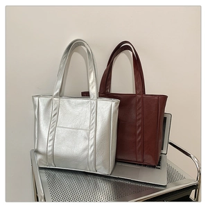 Close-up of silver and deep burgundy tote bags featuring realistic faux leather textures
