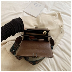 Internal view of brown leather crossbody bag with multiple layers and ethnic embroidery strap