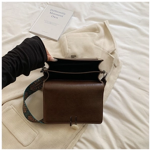 Top view of retro small square bag showing three internal compartments and ethnic strap