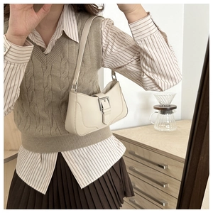 Creamy white crescent armpit bag with silver buckle worn with a casual outfit