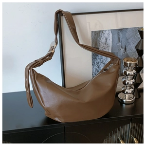 Detailed shot of dark brown moon bag with soft leather texture and silver buckle