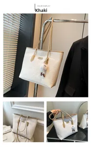 Détail du cabas blanc avec motifs de dessins animés embossés et breloque en peluche