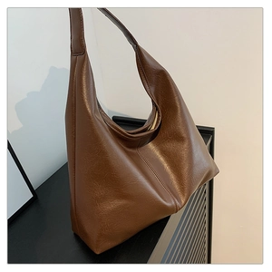 Detail of vintage brown tote bag showing crinkled texture and glossy finish