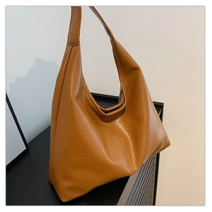 Detail shot of vintage brown tote bag showing soft leather texture and side stitching