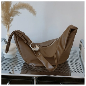 Detail of soft leather hobo bag featuring a large silver metal buckle and zip closure