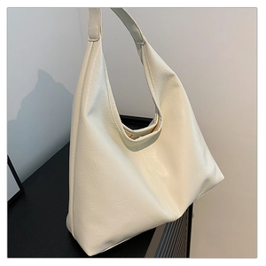 Detail of cream hobo bag showing its soft matte faux leather texture and wide shoulder strap