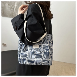 Detail of blue and white woven tote bag with Fashion & Bags leather logo patch