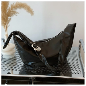 Detail of black crescent hobo bag with industrial silver metal rings and eyelet strap