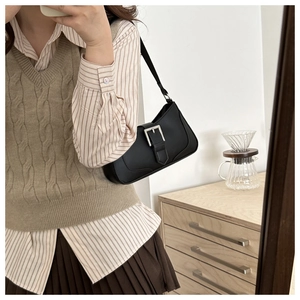 Dettaglio di una borsa sottobraccio in pelle nera chic con fibbia in argento lifestyle