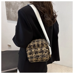 Close-up of khaki crossbody bag with black heart prints and wide white shoulder strap
