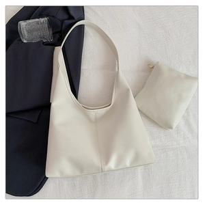 Detail of minimalist cream tote bag set with textured faux leather and vertical stitching