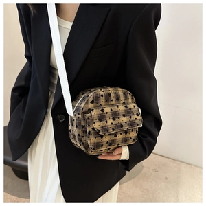 Close-up of checkered mini crossbody bag with heart patterns and wide textile strap